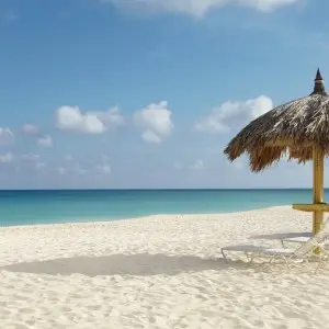 Liegestühle und Sonnenschutz am berühmten Eagle Beach auf Aruba
