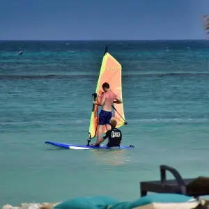 Ein Windsurflehrer gibt seine Tipps zum optimalen Windsurfen an seinen Schüler weiter