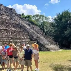 Gruppe an Ausfluggästen steht vor einem der Tempel in Chacchoben